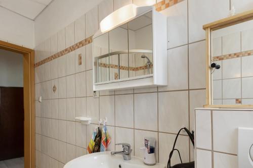 a bathroom with a sink and a mirror and a refrigerator at Ferienwohnung Ruhezone in Gardelegen