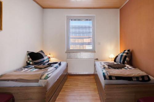two beds in a small room with a window at Ferienwohnung Ruhezone in Gardelegen