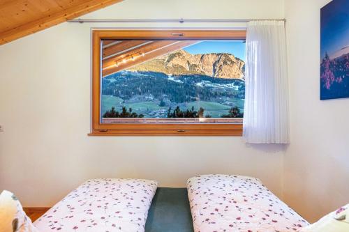 a bedroom with a window with a mountain view at Mittnackerhof Apartment Melisse in Sarntal