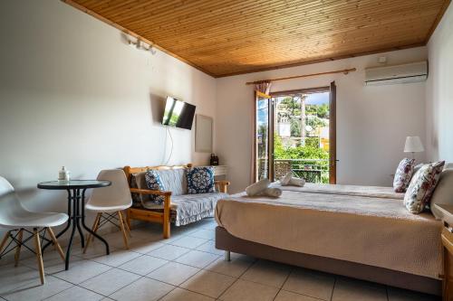 a bedroom with a bed and a table and a couch at Marketos studio 2 in Kefallonia
