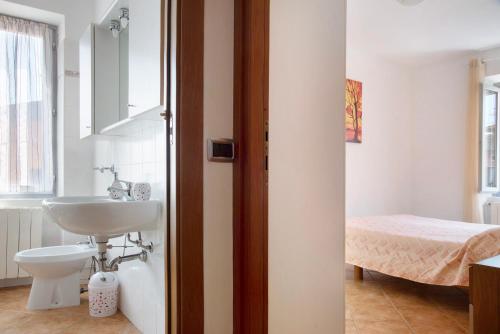 a bathroom with a sink and a toilet and a bed at La Piazzetta in Germignaga