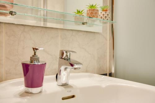 a bathroom sink with a purple soap dispenser on it at Casa Paco in Mogán