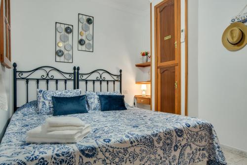 a bed with blue and white sheets and blue pillows at Casa Paco in Mogán