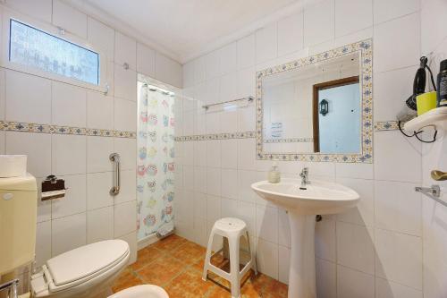a white bathroom with a toilet and a sink at Quinta da Amendoeira in Foz