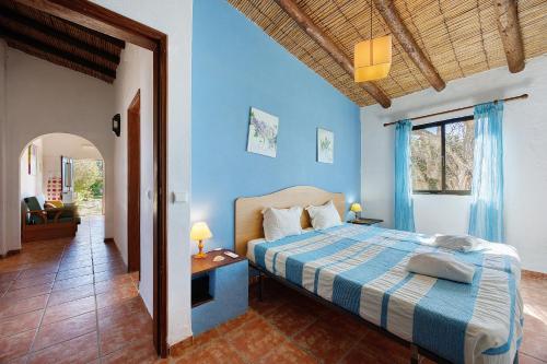 a bedroom with a bed with blue walls at Quinta da Amendoeira in Foz