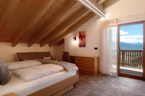 a bedroom with a bed and a large window at Living Lerchna - Schöne Aussicht in Maranza