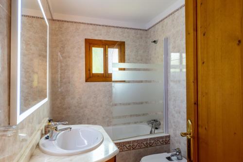 a bathroom with a sink and a toilet and a tub at Sa Carbona in Artá