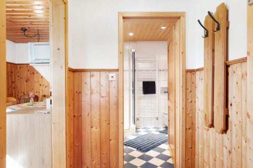 a kitchen with wood paneling and a door leading to a bathroom at Willmannshof in Furtwangen