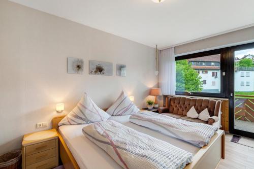 a bedroom with two beds and a large window at Haus Seiler in Freudenstadt