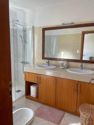 a bathroom with two sinks and a mirror and a shower at Apartamento Jade in Caniço