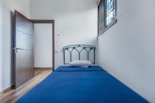 a bedroom with a blue bed and a door at Finca Aramai in Adeje