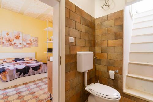 a bathroom with a toilet and a bed at Casa donna Sofia in Specchia