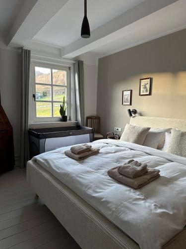 a bedroom with a large white bed with towels on it at Ferienhaus Hallmanns Hof in Schmallenberg