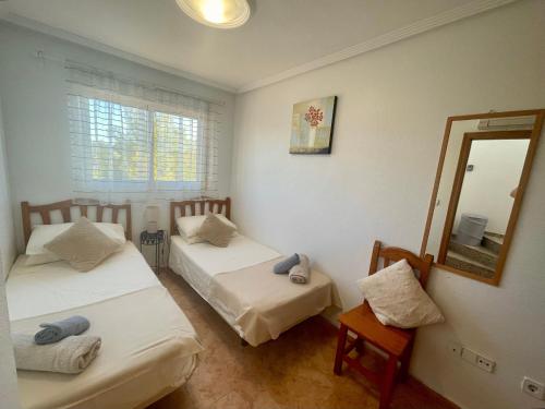 a bedroom with two beds and a mirror at Relax Inn in Pilar de la Horadada