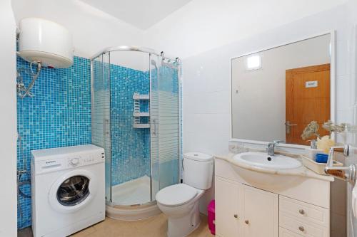 a bathroom with a toilet sink and a washing machine at Alcamar in Alcalá