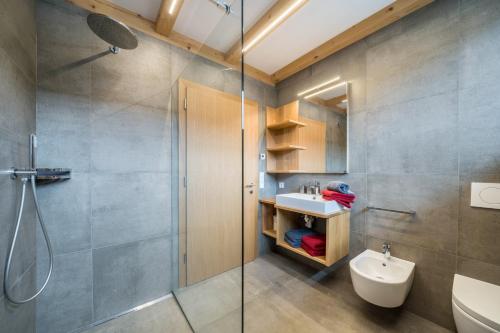 a bathroom with a shower and a sink and a toilet at Parliflhof Apt Langfenn in Meltina