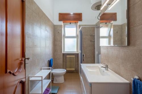 a bathroom with a sink and a toilet and a mirror at Casa Ginevra Salento in San Cassiano
