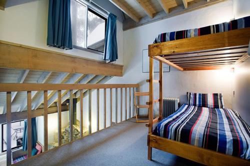 a bedroom with two bunk beds and a staircase at Battys in Dinner Plain