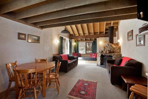 a living room with a table and chairs and a couch at Battys in Dinner Plain