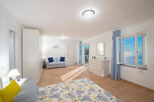 a living room with a bed and a couch and windows at Villa Domus Augusto in Conca dei Marini