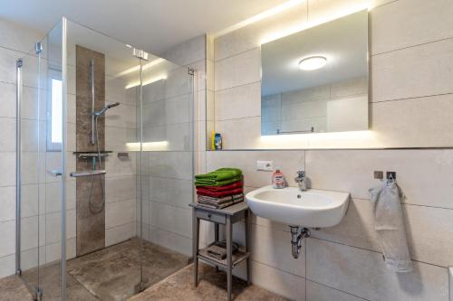 a bathroom with a sink and a shower at Ferienwohnungen Kapellenblick in Biederbach Baden-Württemberg