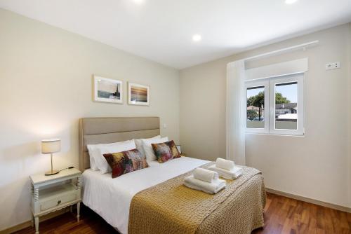 a bedroom with a bed with two towels on it at Pontes Guest House in Arcozelo