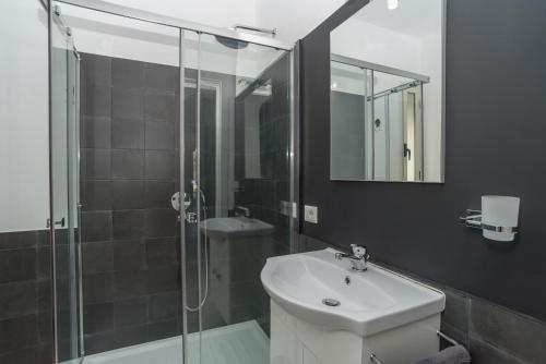 a bathroom with a sink and a glass shower at Villa Marisa in Budoni