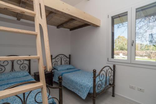 a bedroom with two bunk beds and a window at Villa Marisa in Budoni