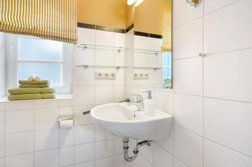 a white bathroom with a sink and a window at Haus Herr Krug in Walkendorf