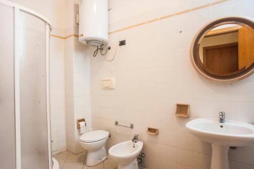 a bathroom with a sink and a toilet and a mirror at Villa erica appartamento Cindy in Villa San Pietro