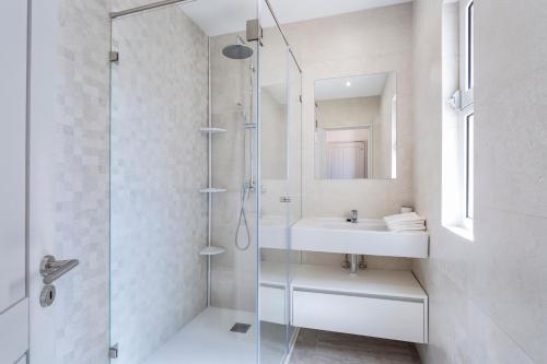 a white bathroom with a shower and a sink at Villa Isabel in Vale do Lobo