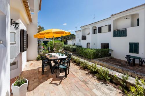 a patio with a table and chairs and an umbrella at Villa Isabel in Vale do Lobo