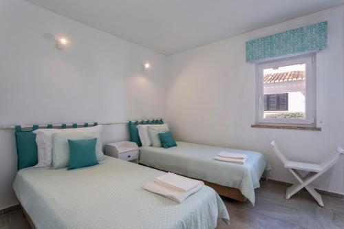 a bedroom with two beds and a window at Villa Isabel in Vale do Lobo