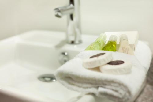 a bathroom sink with a white towel on a sink at Hotel Los Andes in San Pedro Sula