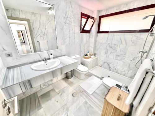 a white bathroom with a sink and a toilet at Villa with Private Pool in Estepona