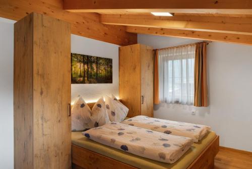 a bedroom with a bed with a wooden frame at Ferienwohnung Haus Brugger in Uttendorf