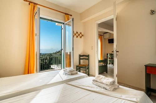 a bedroom with a bed and a large window at Anemona apartment 2 in Kefallonia
