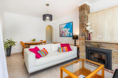 a living room with a white couch and a fireplace at Es Claper in Cala Ratjada