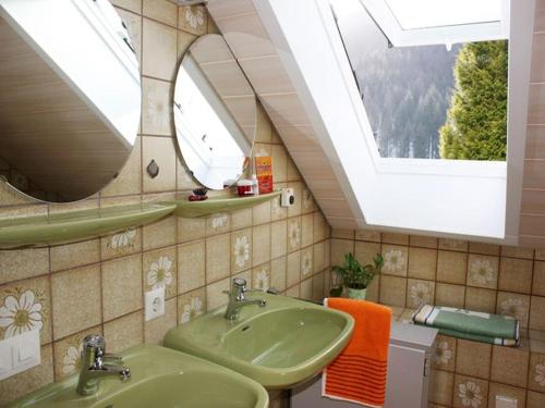 a bathroom with two sinks and a skylight at Haus Margot Armbruster in Bad Rippoldsau-Schapbach
