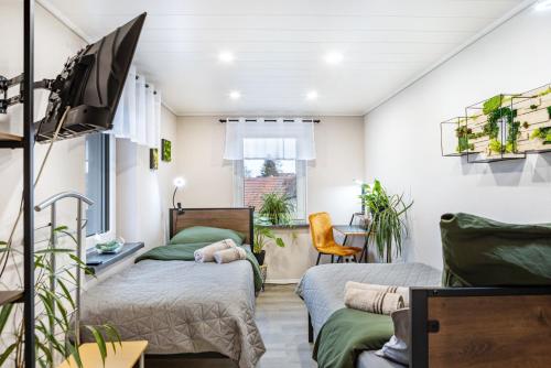a bedroom with two beds and a tv at Ferienhaus Kirsch in Blankenhain