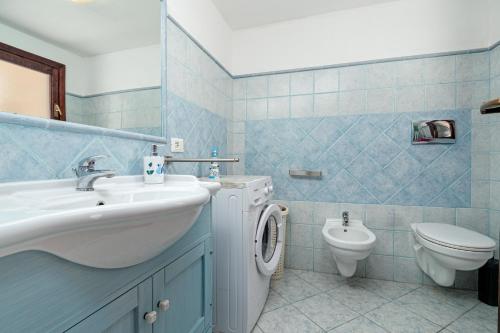 a bathroom with a sink and a washing machine at Villetta i Gerani in San Teodoro