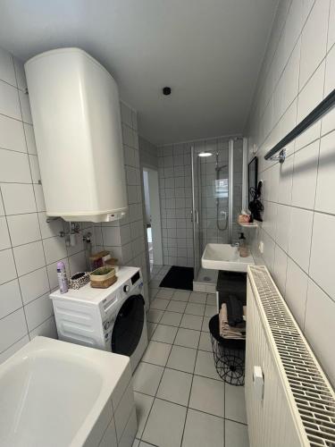a white bathroom with a sink and a tub at Charmante Altbauwohnung in Erlangen
