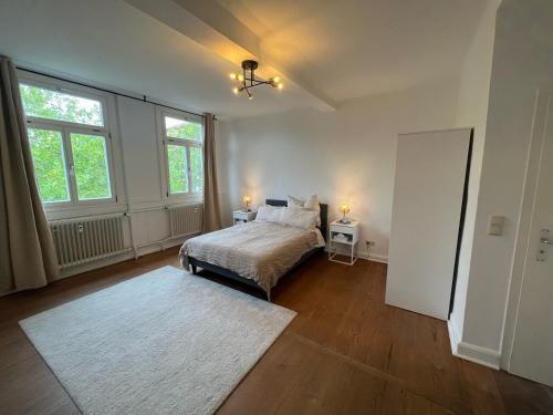 a bedroom with a bed and two windows and a rug at Charmante Altbauwohnung in Erlangen