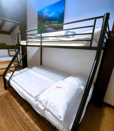two bunk beds in a room with white sheets at Haus Seidelbast in Siegsdorf