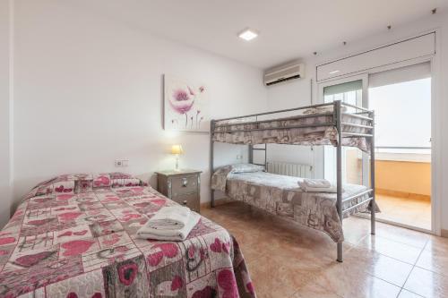 a bedroom with two bunk beds and a window at Malgrat in Malgrat de Mar