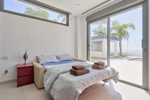 a bedroom with a bed and a large window at Villa Palacio Nazari in Málaga