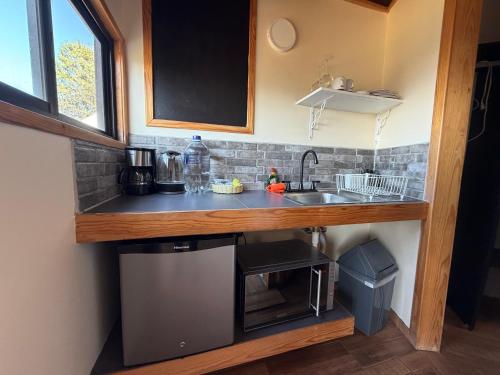 a kitchen with a sink and a microwave at Glamping Las Nubes in Chignahuapan