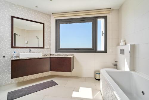 a bathroom with a tub and a sink and a mirror at Villa Palacio Nazari in Málaga