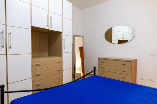 a bedroom with a blue bed and a mirror at Terra in Follonica