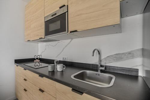 a kitchen with a sink and a microwave at Casa Us in Arinaga